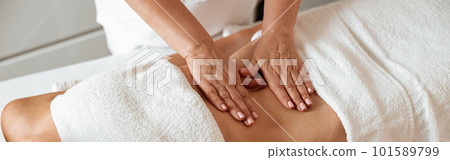 Female client receiving stomach massage in spa salon Female client receiving stomach massage in spa salon 101589799