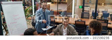 Mature business coach or speaker make flip chart presentation to diverse businesspeople at meeting 101590236