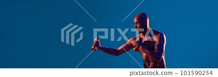 Muscular man doing exercise with weight dumbbells on studio background. Strength and motivation 101590254