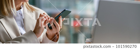 Close up of businesswoman use phone during working on laptop in cafe. Distance work concept 101590270