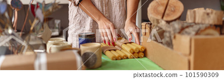 Close up of woman is packing handmade candles for selling in own home decor studio Close up of woman is packing handmade candles for selling in own home decor studio 101590309