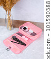 A beautiful pink cosmetic bag with the necessary products for the care of women's skin. Cosmetics, shampoo, creams, makeup brushes in a cosmetic bag against the backdrop of a beautiful women's room. 101590388