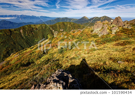 View of Mt. Hiuchi, Mt. Yake and the Shirouma mountain range from the summit of Mt. Myoko in early autumn 101590434
