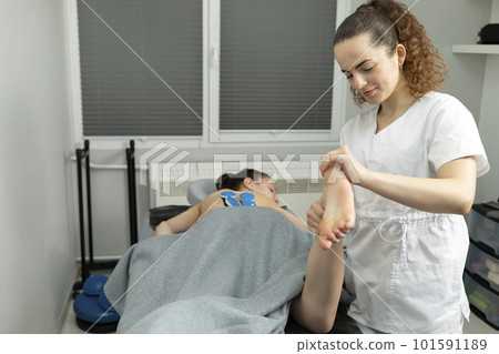Rehabilitation Specialist, Physical Therapist Makes Foot Massage To Child With Cerebral Palsy, Scoliosis. Health Specialist, Rehabilitation. Horizontal plane. Rehabilitation Specialist, Physical Therapist Makes Foot Massage To Child With Cerebral Palsy, Scoliosis. Health Specialist, Rehabilitation. Horizontal plane. 101591189