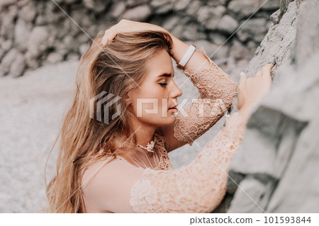 Woman summer travel sea. Happy tourist in beige dress enjoy taking picture outdoors for memories. Woman traveler posing on the beach surrounded by volcanic mountains, sharing travel adventure journey Woman summer travel sea. Happy tourist in beige dress enjoy taking picture outdoors for memories. Woman traveler posing on the beach surrounded by volcanic mountains, sharing travel adventure journey 101593844