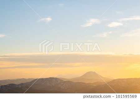 夕陽的天空和遠處朦朧的山脈 夕陽的天空和遠處朦朧的山脈 101595569