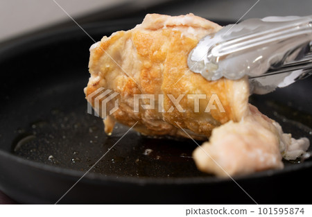 chicken being cooked in a frying pan 101595874
