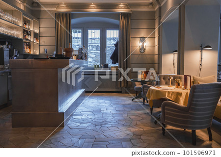 Empty armchairs and tables arranged in front of bar counter in luxurious restaurant at tourist resort, luxury travel concept for tourists Empty armchairs and tables arranged in front of bar counter in luxurious restaurant at tourist resort, luxury travel concept for tourists 101596971