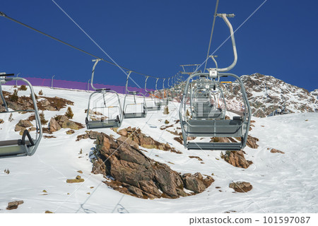 Empty ski lifts over snow covered landscape with mountains in background, winter holiday travel concept Empty ski lifts over snow covered landscape with mountains in background, winter holiday travel concept 101597087