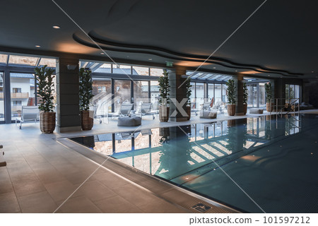 Potted plants arranged by columns in front of empty swimming pool at luxurious modern hotel, luxury vacation and holiday concept for tourists Potted plants arranged by columns in front of empty swimming pool at luxurious modern hotel, luxury vacation and holiday concept for tourists 101597212