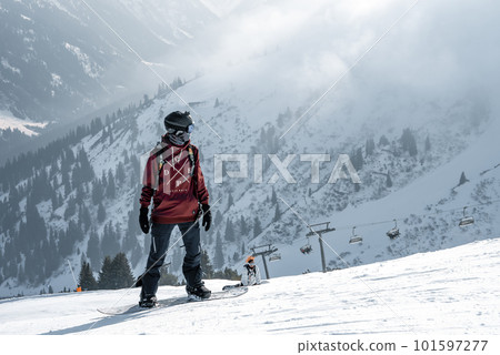 Tourist with snowboard on snow covered mountain with beautiful landscape in background during winter vacation, winter holiday travel concept Tourist with snowboard on snow covered mountain with beautiful landscape in background during winter vacation, winter holiday travel concept 101597277