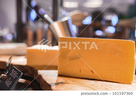 Closeup of mountain cheese pieces with tag on wooden table at luxurious hotel restaurant, luxury travel and food concept Closeup of mountain cheese pieces with tag on wooden table at luxurious hotel restaurant, luxury travel and food concept 101597360