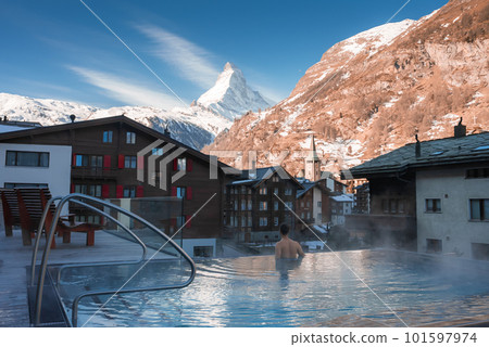 Luxury infinity outdoors pool with an amazing view at the Matterhorn peak in Zermatt, Switzerland.  101597974