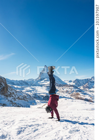 Young snowboarder spending winter holidays in Zermatt, near the famous Matterhorn peak. Male posing in Swiss Alps for the snowboarding season. 101597987