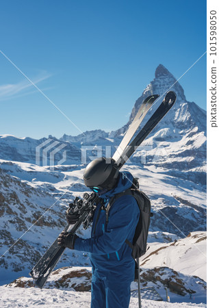 Young skier enjoying Zermatt ski resort. Beautiful sunny day with a skier up in the mountains. Sports model. Young skier enjoying Zermatt ski resort. Beautiful sunny day with a skier up in the mountains. Sports model. 101598050