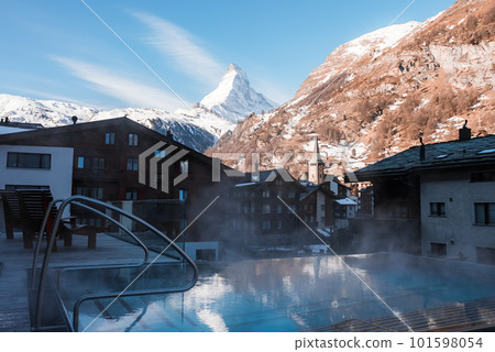 Luxury infinity outdoors pool with an amazing view at the Matterhorn peak in Zermatt, Switzerland.  101598054