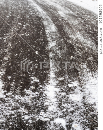icy surface of asphalt road on overcast winter day 101598903