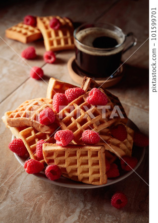 Belgian waffles with raspberries and black coffee. 101599701