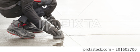 Ground wire. A worker lays a ground cable on the roof of a building. Electrician fixing aluminum wire for grounding solar panels Ground wire. A worker lays a ground cable on the roof of a building. Electrician fixing aluminum wire for grounding solar panels 101602706
