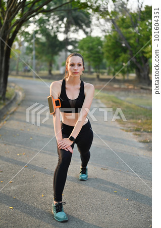 Delighted athletic woman in sportswear jogging in public park. Healthy lifestyle, sport, wellness concept Delighted athletic woman in sportswear jogging in public park. Healthy lifestyle, sport, wellness concept 101604351
