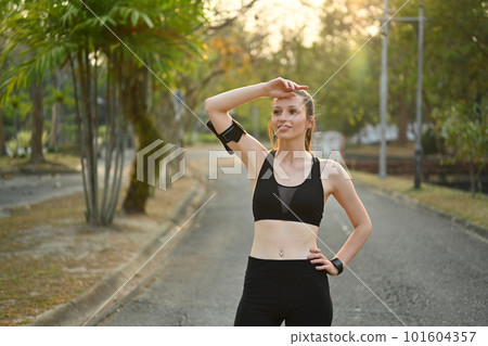 Portrait of athletic woman taking a break from fitness training in the park with beautiful sunlight Portrait of athletic woman taking a break from fitness training in the park with beautiful sunlight 101604357