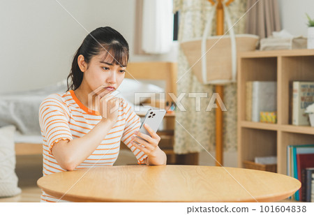 A young woman using a smartphone in the living room 101604838