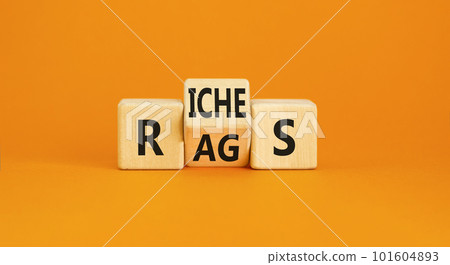 Rags or riches symbol. Concept word Rags Riches on wooden cubes. Beautiful orange table orange background. Business and rags or riches concept. Copy space. 101604893