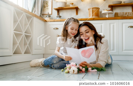 Daughter giving mother bouquet of flowers. 101606016