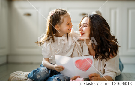 Daughter giving mother postcard. 101606018