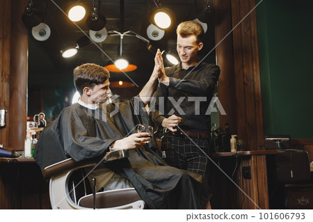 Man sitting in a chair. Hairdresser with a client. Guy drinkig a whiskey. 101606793