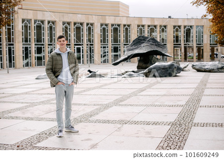 Portrait of attractive man with casual clothes walk in Europe. a guy in a jacket stands on street during the fall season. Portrait oh handsome teen guy, young man in hoodie, down jacket standing Portrait of attractive man with casual clothes walk in Europe. a guy in a jacket stands on street during the fall season. Portrait oh handsome teen guy, young man in hoodie, down jacket standing 101609249
