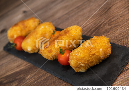 Homemade traditional Spanish croquettes or croquetas on a black plate with fork, Tapas food 101609484