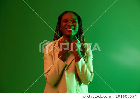 African american woman portrait business smile on green background in neon light, color mixed light, bright colors. Beauty African American woman with pigtails emotions. African american woman portrait business smile on green background in neon light, color mixed light, bright colors. Beauty African American woman with pigtails emotions. 101609554