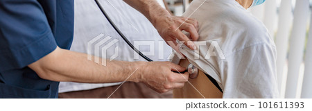 Close up of doctor listening to old woman's patient breathing, using stethoscope 101611393