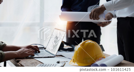 Architect and Engineer working with blueprints for architectural plan, engineer sketching a construction project, green energy concept 101611425