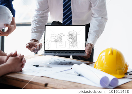 Architect and Engineer working with blueprints for architectural plan, engineer sketching a construction project, green energy concept Architect and Engineer working with blueprints for architectural plan, engineer sketching a construction project, green energy concept 101611428