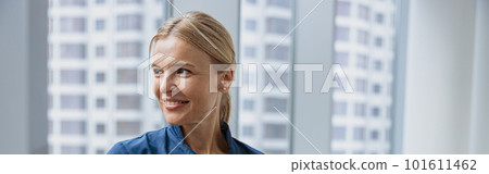 Female healthcare worker using laptop while working at doctor's office and looking window Female healthcare worker using laptop while working at doctor's office and looking window 101611462