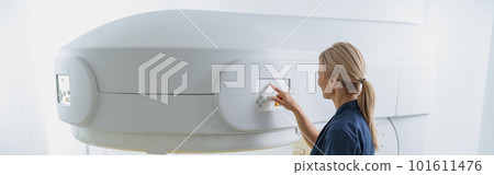 Radiologist controls MRI or CT or PET Scan with female patient undergoing procedure 101611476