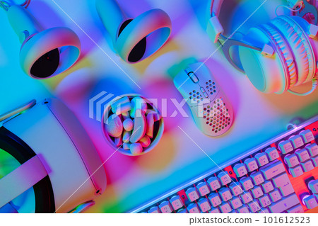 Top view of various modern gadgets on professional multi colored gaming desk 101612523