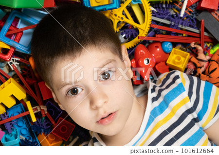 A pensive 5-year-old boy thinks while looking away while lying among scattered toys. Logic and development for preschoolers and schoolchildren A pensive 5-year-old boy thinks while looking away while lying among scattered toys. Logic and development for preschoolers and schoolchildren 101612664