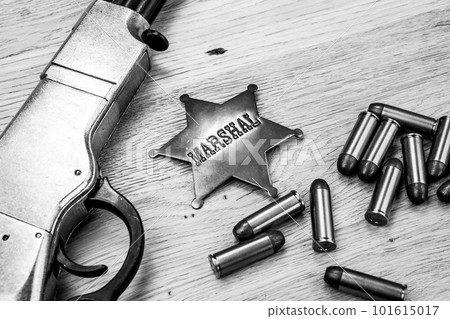 Old west repeating rifle with ammunition and marshals badge. 101615017