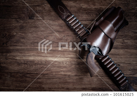 Old west weapon. Colt Revolver and gunbelt with holster on wooden deck. Old west weapon. Colt Revolver and gunbelt with holster on wooden deck. 101615025