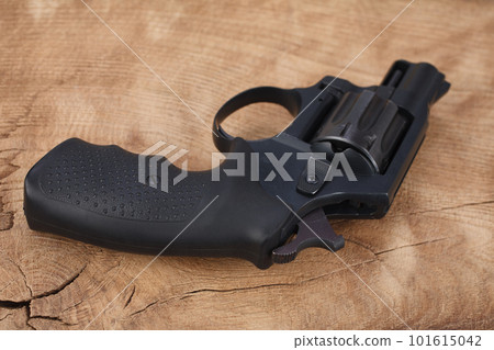 Cocked revolver on wooden table Cocked revolver on wooden table 101615042