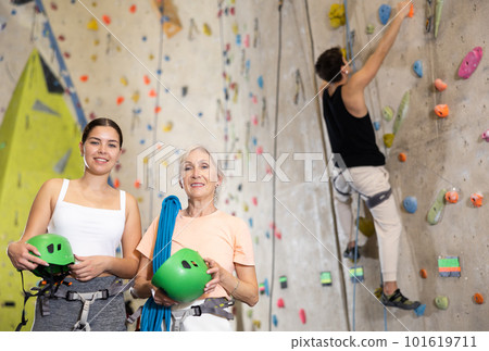 Confident young and senior female climbers with their equipment getting ready for training 101619711