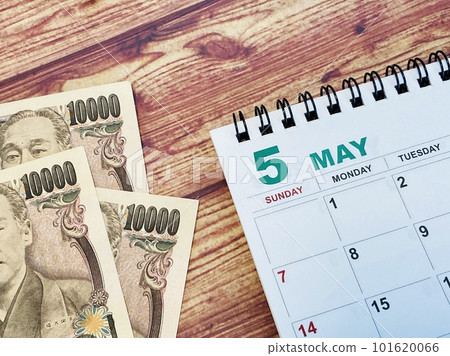 May calendar and 30,000 yen on a wooden desk 101620066