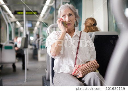 Woman talking on phone in tram 101620119