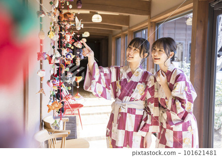 一位年輕女子看著過道上掛著的娃娃 一次女孩旅行的形象 101621481