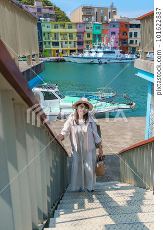 woman traveler visiting in Taiwan, Tourist with hat sightseeing in Keelung, Colorful Zhengbin Fishing Port, landmark and popular attractions near Taipei city . Asia Travel concept 101622887