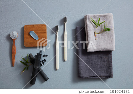 Flat lay folded towels, toothbrushes and activated charcoal toothpaste for dental care concept Flat lay folded towels, toothbrushes and activated charcoal toothpaste for dental care concept 101624181
