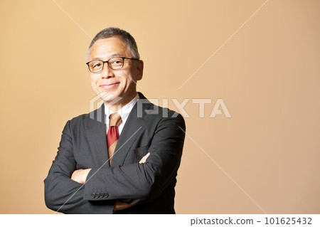 Business image of a senior man in a suit looking while folding his arms 101625432